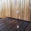 Spots extérieurs fixés sur un bardage en bois pour former une balise lumineuse.